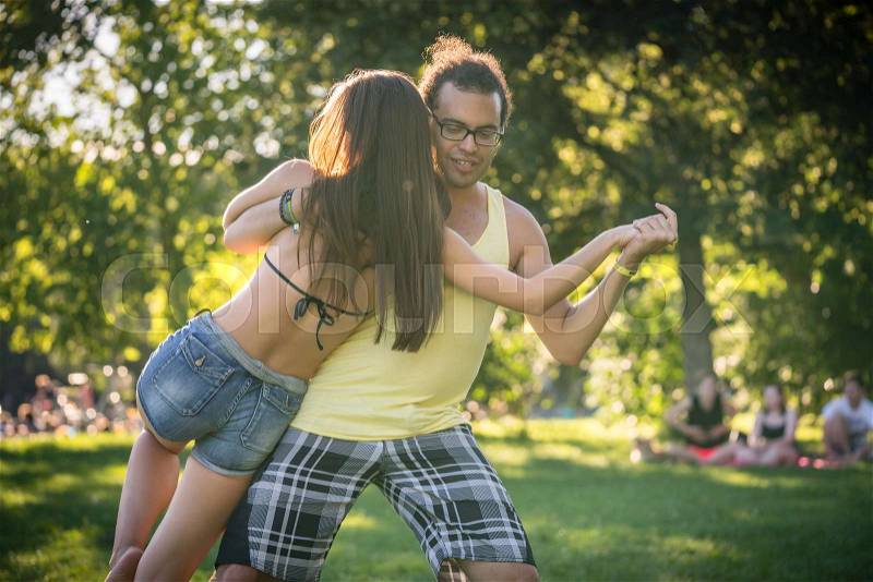 Man and woman dancing dip move training Latin American dance outdoors, stock photo