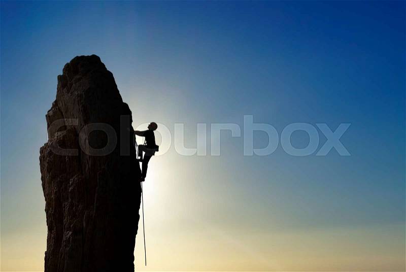 Man rock climber silhouette over bright sky background, stock photo