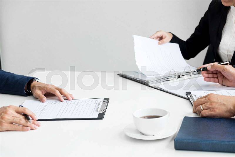 Businessman conducting an interview with businessman in an office, stock photo