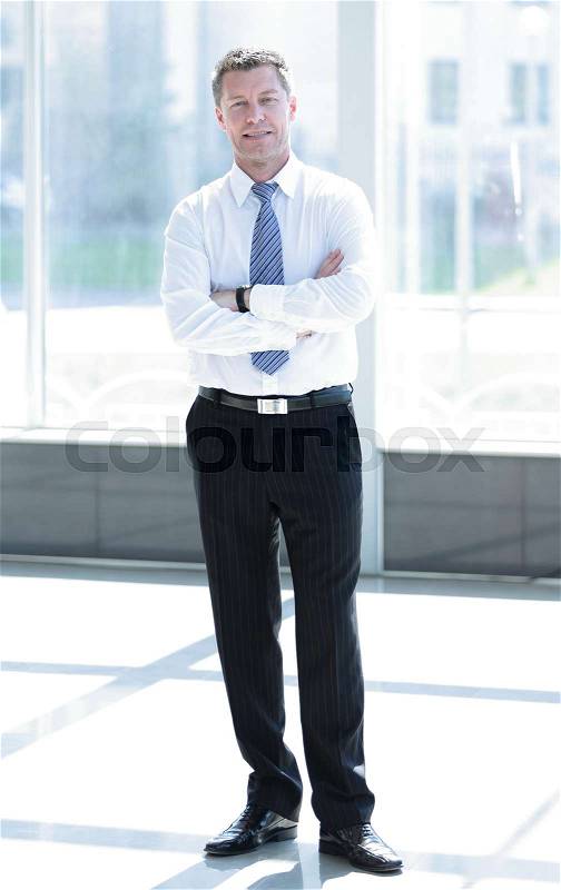 Full length portrait of confident mature businessman in formals standing at office, stock photo