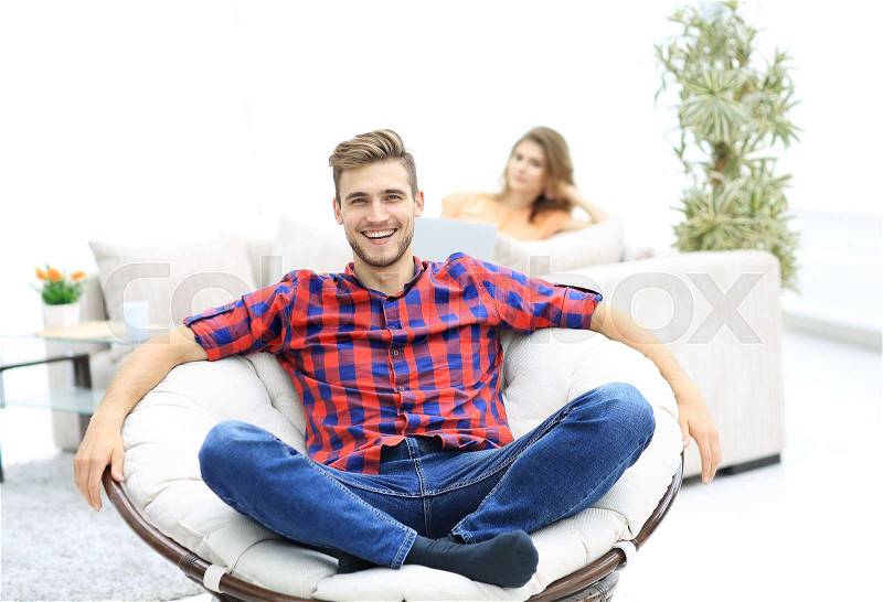 Modern young man sitting in a big round chair on blurred background.photo with copy space, stock photo