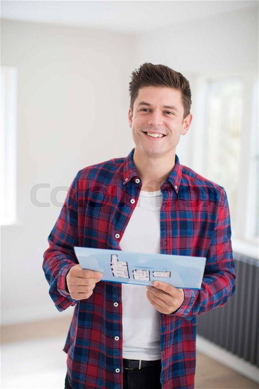 Man Looking At Brochure With Details For New Home, stock photo