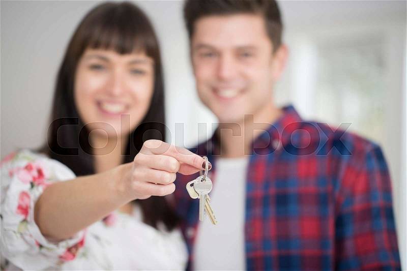 Portrait Of Young Couple Holding Keys To New Home, stock photo