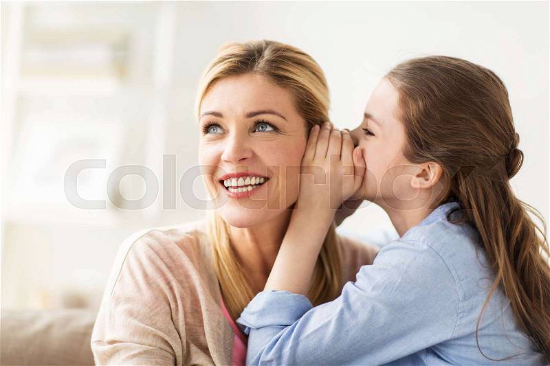People, trust and family concept - happy daughter whispering secret to her mother at home, stock photo