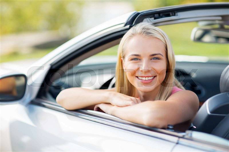 Travel, road trip and people concept - happy young woman in convertible car, stock photo