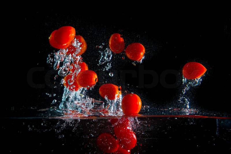 Tomatoes splashing in the water, stock photo