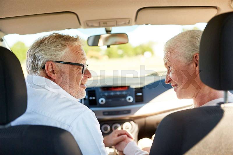 Road trip, travel and old people concept - happy senior couple driving in car, stock photo