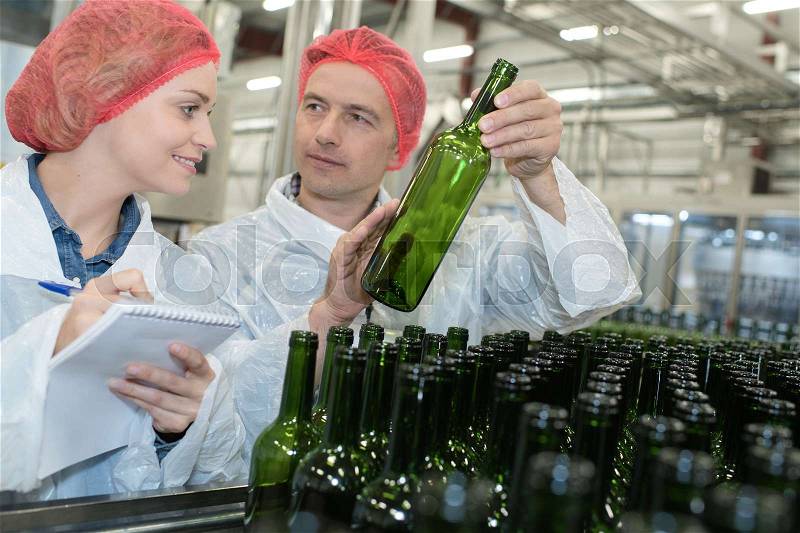 Packers working on the bottling line at the manufacture, stock photo