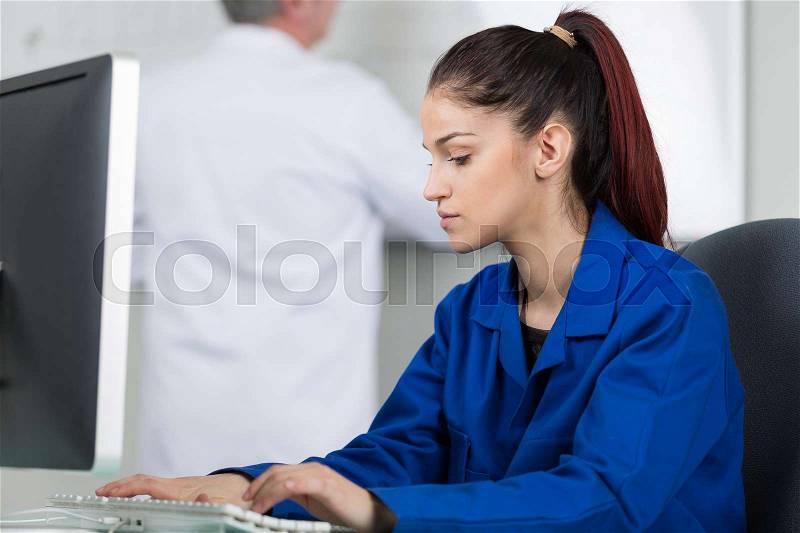 Female tutor using computer in it class, stock photo