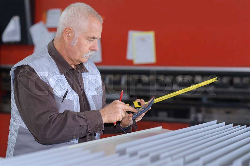Portrait of elder man working at the factory, stock photo