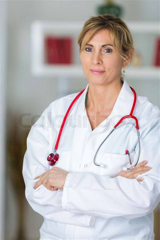 Portrait of confident female doctor standing arms crossed in clinic, stock photo