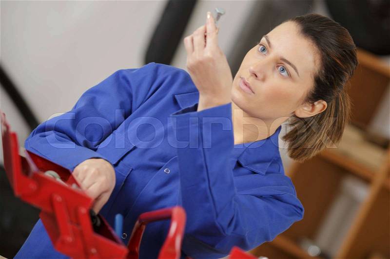 Woman looking for tool in her tool box, stock photo