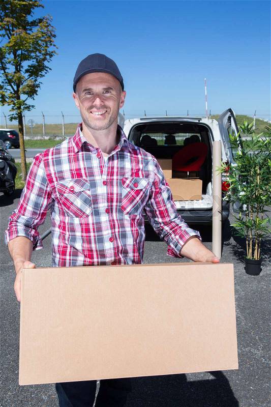 Delivery man carrying box, stock photo