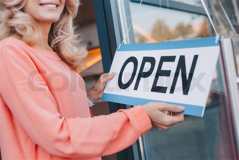 Cropped shot of smiling cafe owner holding sign open , stock photo