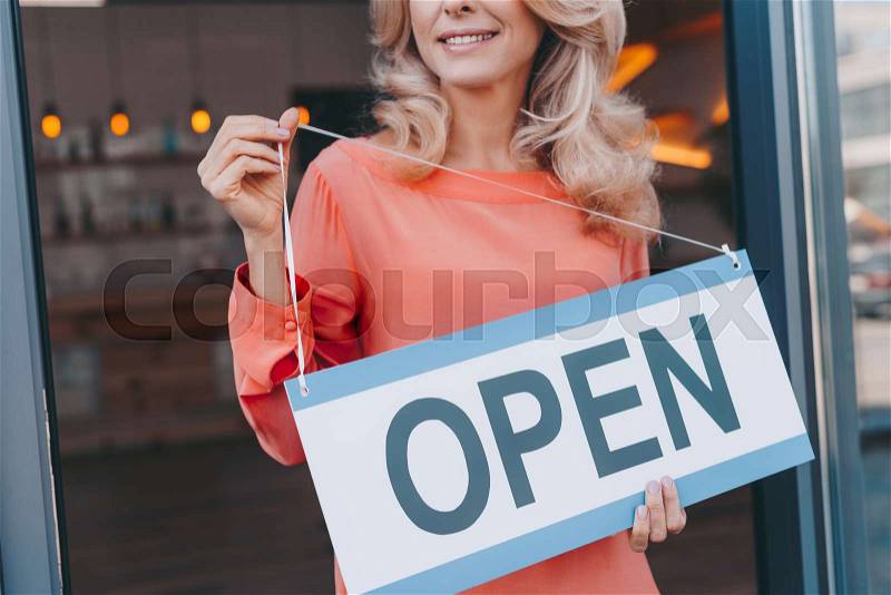 Cropped shot of happy small business owner holding sign open , stock photo