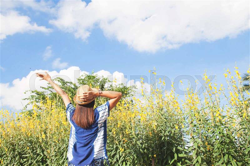 Happiness long hair woman in casual clothing with yellow flowers field, stock photo