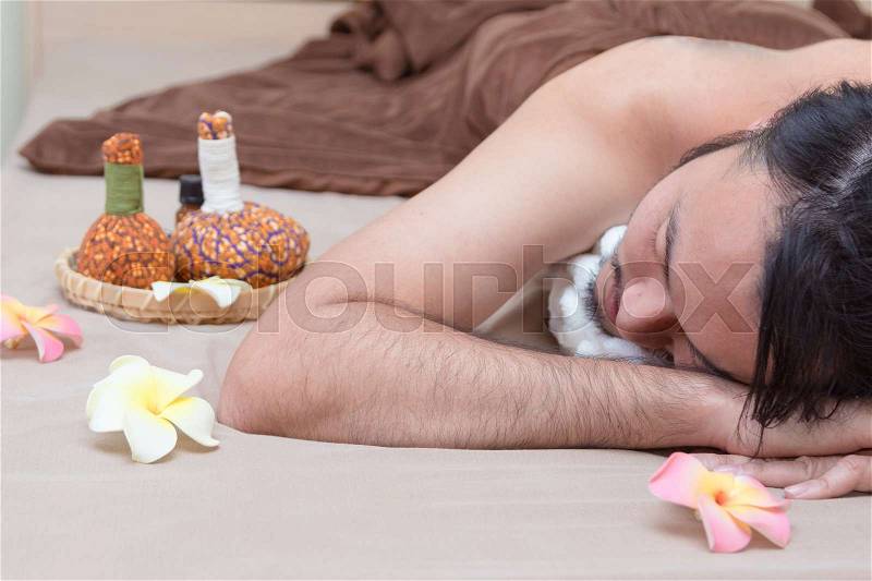 Happy Asian man lying on the massage table and smiling, spa concept, stock photo