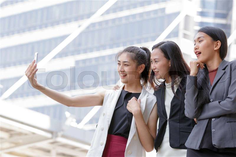 Happy Asian girls best friends laugh and smile while taking selfie from smart phone , stock photo
