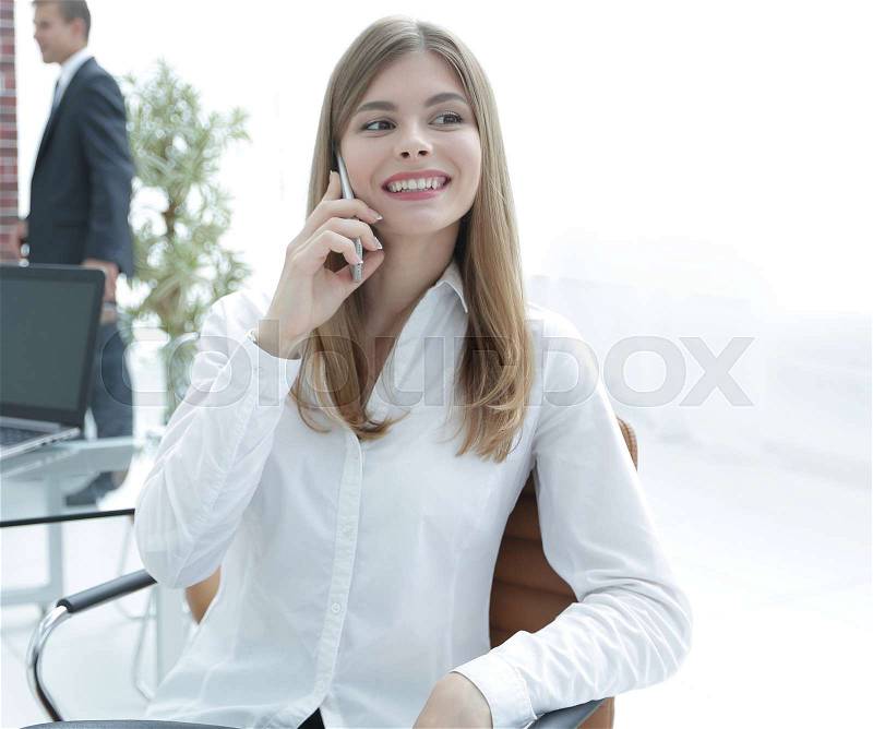 Closeup.female assistant talking on mobile phone in office. photo with copy space, stock photo
