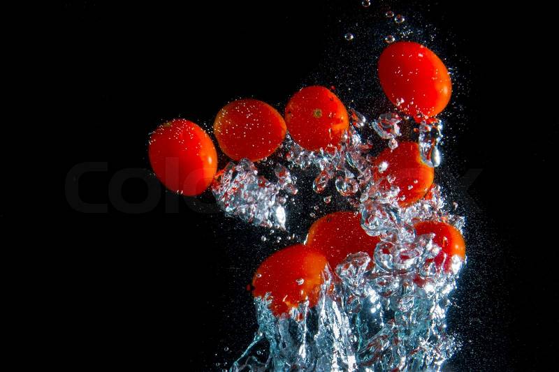 Tomatoes splashing in the water, stock photo