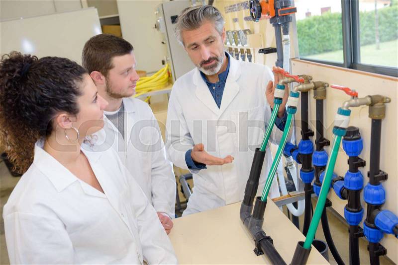 Engineer student turning pipeline pump for training in laboratory, stock photo