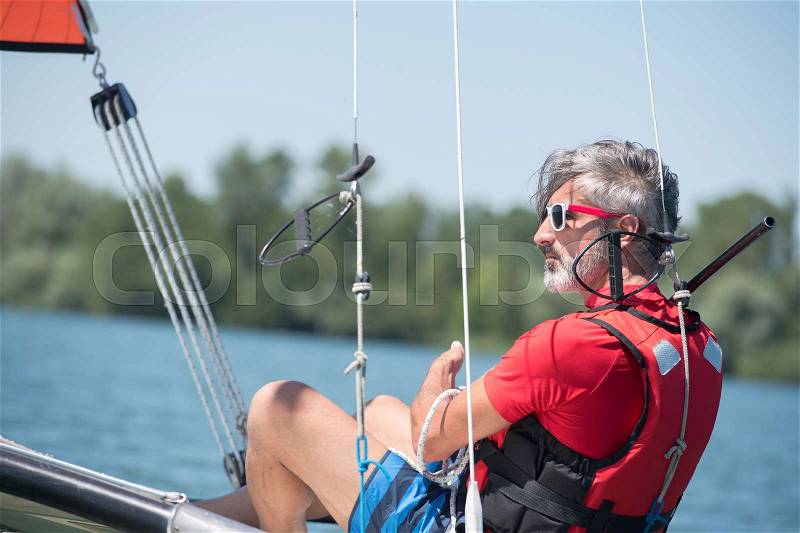 Young man skipper at his sail boat, stock photo
