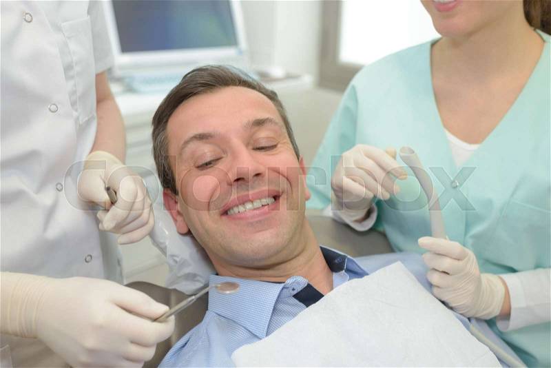 Happy young man smiling in the dentists chair, stock photo