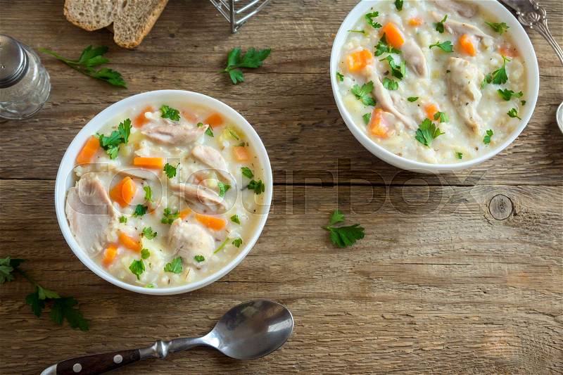 Chicken and Wild Rice Soup. Homemade fresh creamy soup with chicken, vegetables and wild rice in white bowl, copy space, stock photo