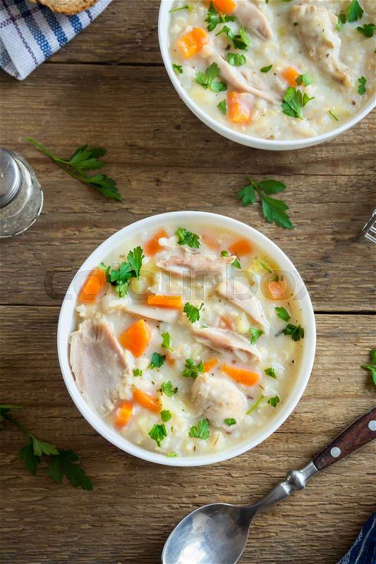Chicken and Wild Rice Soup. Homemade fresh creamy soup with chicken, vegetables and wild rice in white bowl close up, stock photo