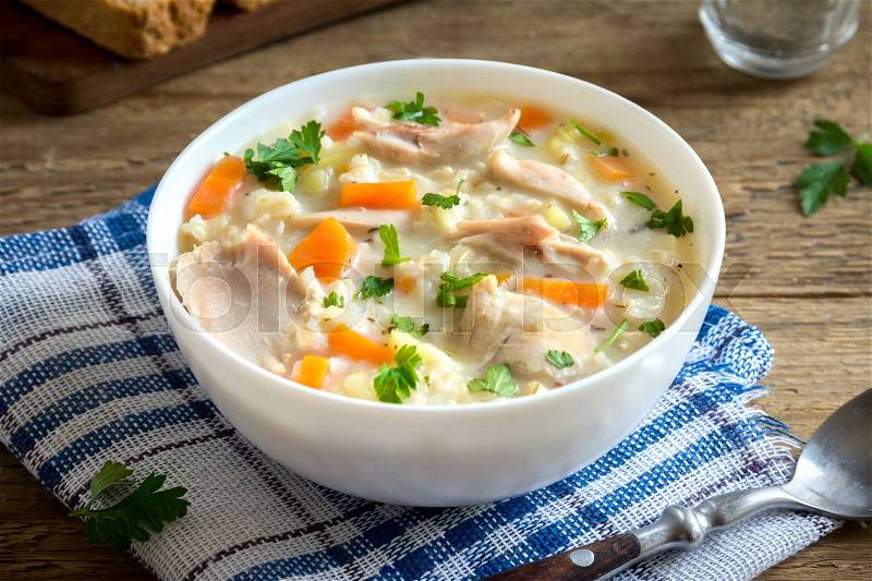 Chicken and Wild Rice Soup. Homemade fresh creamy soup with chicken, vegetables and wild rice in white bowl close up, stock photo