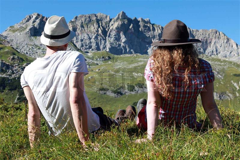 Young people make a short break during a hiking tour in the Austrian Alps, stock photo