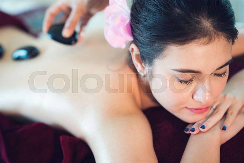 Hot black stone spa and Asian lady relax in spa in resort, Thailand, Asia, stock photo