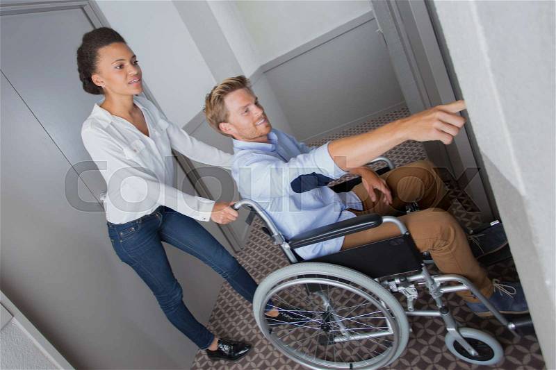Waiting for elevator girlfriend and boyfriend wheelchair, stock photo