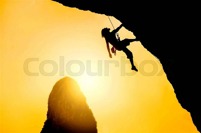 Silhouette of man climbing at sunset. Extreme sport concept, stock photo