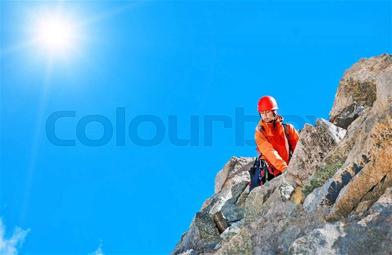 A lonely climber reaching the summit, stock photo