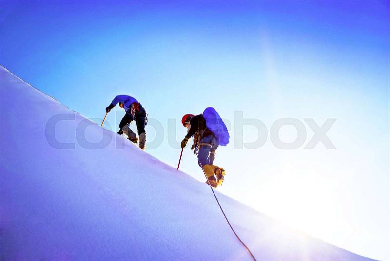 Team of two alpinists climbing a mountain. Extreme sport concept, stock photo