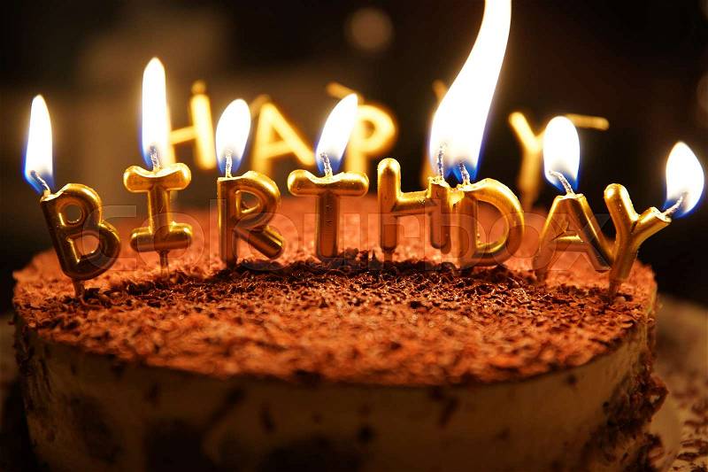 Happy birthday candle with fire on a cake, stock photo