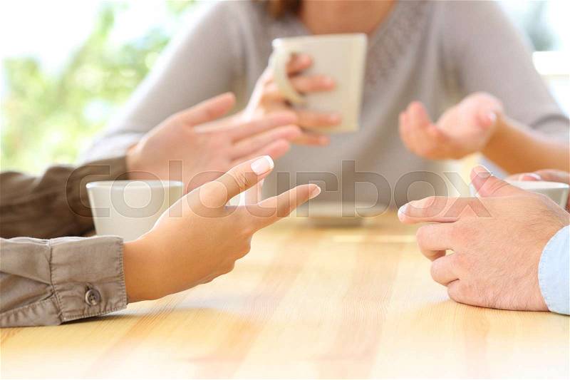 Close up of three friends hands talking sitting in a bar or house, stock photo