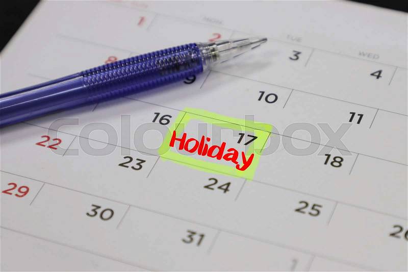 Yellow highlighter with a circled holiday day on calendar, stock photo