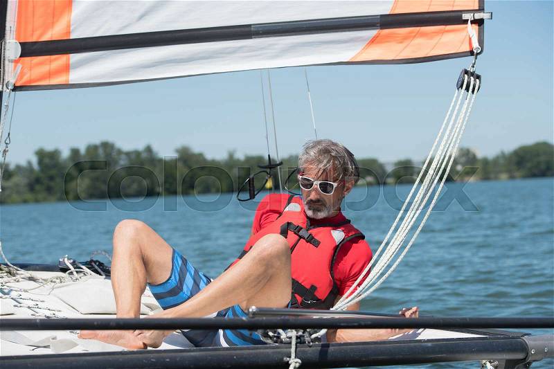 Man sailing and dreams on river at summer day, stock photo