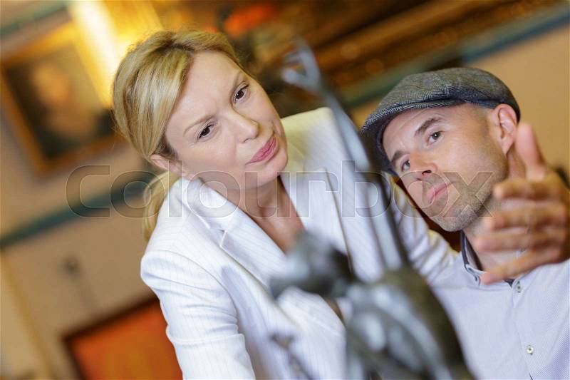 Artist looking at the creative sculpture in art gallery, stock photo