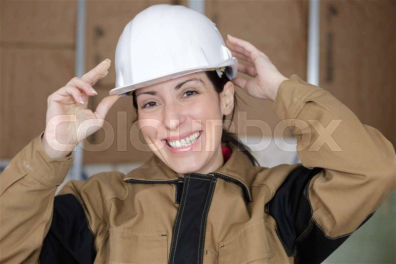 Female worker with hard hat smiling, stock photo