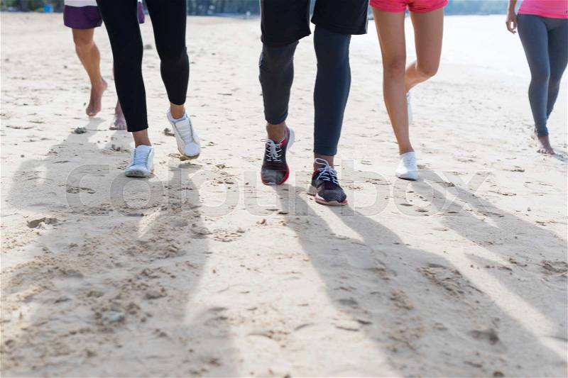 Group Of Young People Running On Beach Feet Closeup Sport Runners Jogging Working Out Team Training Together On Seaside, stock photo