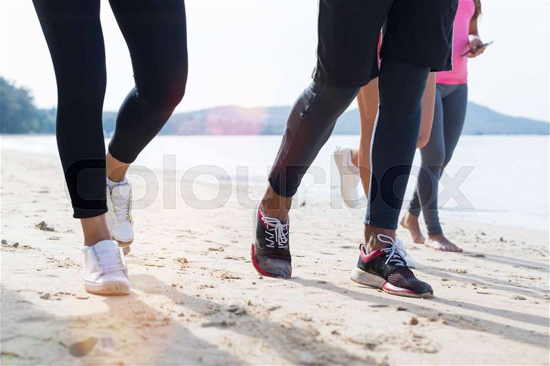 Closeup Of Group Of People Running On Beach Feet Shot Sport Runners Jogging Working Out Team Men And Women Fitness Training Together On Seaside, stock photo