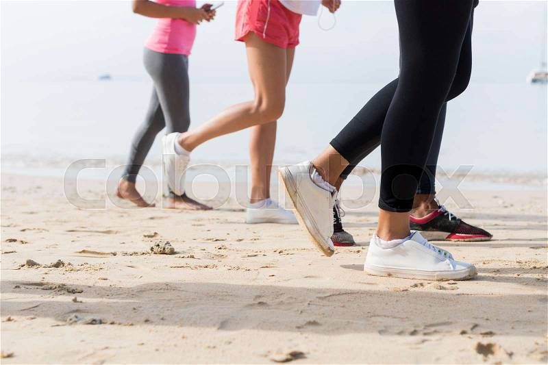 View Of Feet Running On Beach Together Closeup Of Sport People Runners Jogging Working Out Team Training Together On Seaside, stock photo