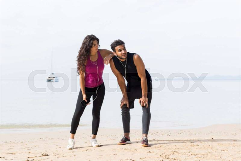 Couple Of Runner Having Rest After Training On Beach Man And Woman Sport Runners Standing Fit Male And Female Fitness Jogger On Seaside Together, stock photo