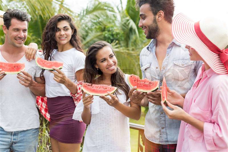Happy Young Group Of Friends Talking Hold Watermelon Slice Outdoors Cheerful Mix Race People Communicating Eat Water Melon On Picnic, stock photo