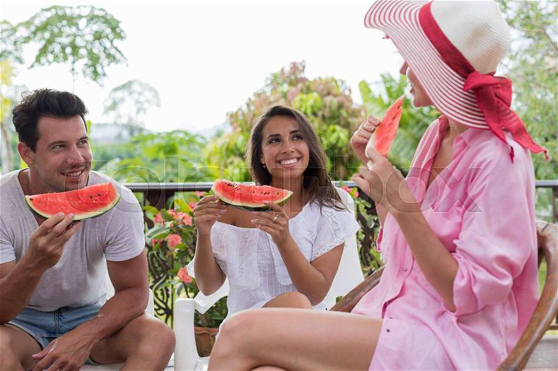Young People Group Talking Holding Slice Of Watermelon While Meeting On Summer Terrace Friends Enjoy Communication And Fresh Fruits Together, stock photo