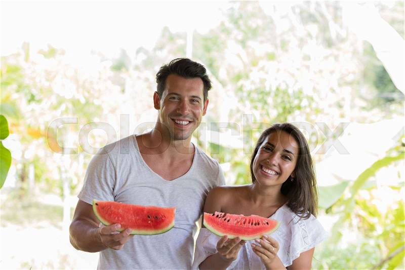Happy Couple Holding Water Melon Slice In Hands Cheerful Smiling Man And Woman Embrace With Watermelon Outdoors On Summer Terrace, stock photo