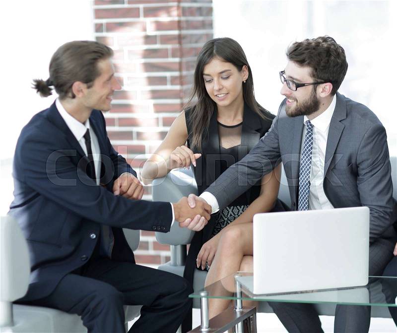Handshake business partners,sitting on the sofa in the office lobby, stock photo